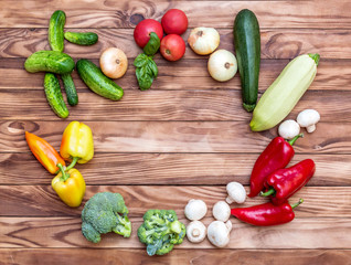 Frame from different vegetables on wooden background.Top view. Space for text.