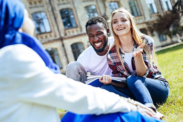 Laughing out loud. Cheerful young people laughing and smiling while going out and chatting outdoors together.