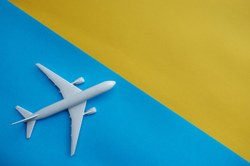 Copyspace of white airplane on blue and yellow background
