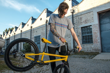 Bmx rider holding his bike outdoors on the street