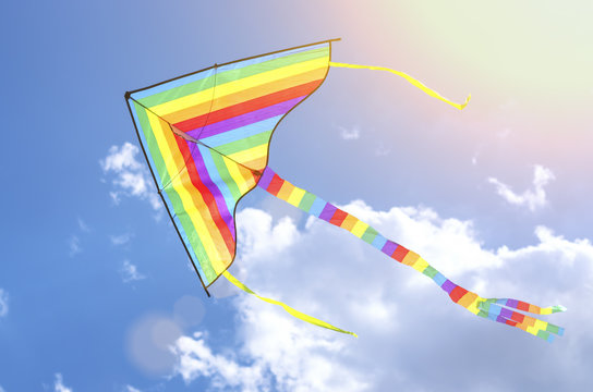colorful flying kite flying in the sky with clouds, in the sunlight