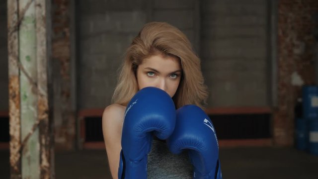 Young fitness girl with bloxing gloves looking at camera over background portrait young student girls happy smiling sport