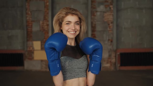 Young fitness girl with bloxing gloves looking at camera over background portrait young student girls happy smiling sport