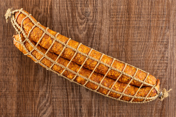 Group of two whole dry smoked ham sausage flatlay on brown wood