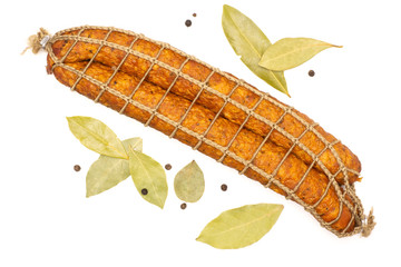 Group of two whole dry smoked ham sausage with dry bay laurel leaves and pepper flatlay isolated on white