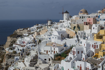 Fototapeta na wymiar Whitewashed Houses and Windmill on Cliffs with Sea View in Oia, Santorini, Cyclades, Greece