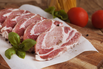 Raw pork meat with spices, wooden cutting board. Food Cooking Ingredient. Top view with copyspace.