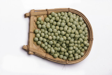Green peas in cane basket isolated on white background