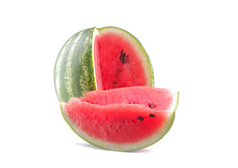 A large ripe watermelon and two slices are next to a white background. isolated