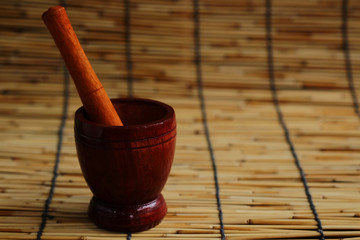 Wood mortar and pestle on wood mat and wall with some space for write wording, unique Asian...