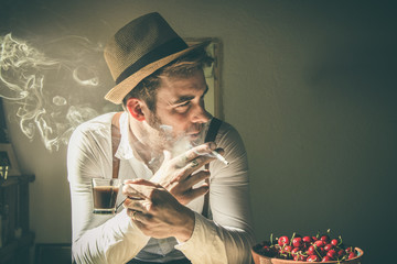 Guy drinking coffee and smoking a cigarette.