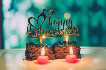 Happy Anniversary Sign on Chocolate Brownie with lit candles - 214106715