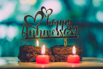Happy Anniversary Sign on Chocolate Brownie with lit candles - 214106733