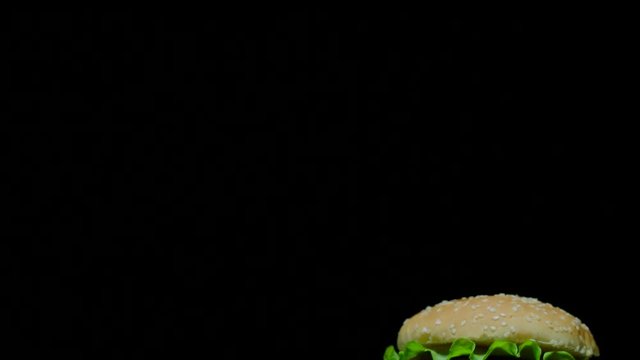 Close up of delicious burger with double cheese and french fries. Black background