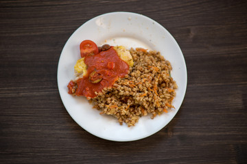 photo of a real meal on a dark background on a white plate.