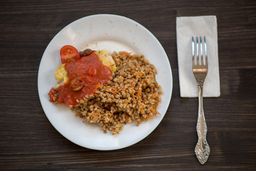photo of a real meal on a dark background on a white plate.