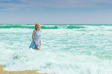 Woman in blue dress in the water in the ocean, the sea.