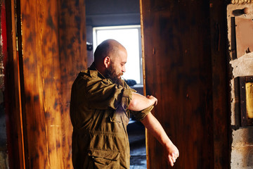 Man's den workshop inside man rolling up sleeves before work