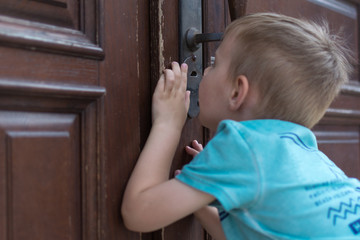 the child peeps through the keyhole.