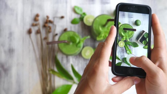 Hands Taking Photo Of Green Smoothie With Smart Phone