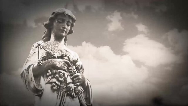 goth gravestone statue angel with timelapse clouds