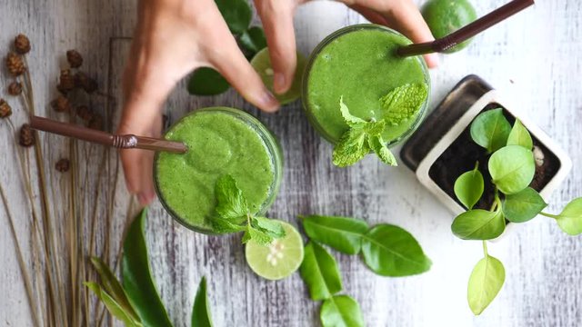 Hands With Green Detox Smoothie On Wooden Table. Trendy Flat Lay.