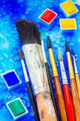 Obraz premium colorful set of watercolor paints and brushes close up, retro toned