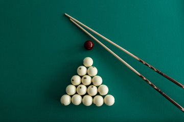 Russian billiard balls, cue, triangle, chalk on a table.