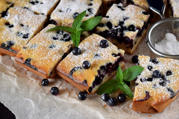 Finnish bilberry pie cut into square pieces sprinkled with sugar powder