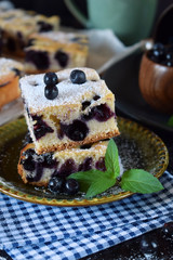 Finnish bilberry pie cut into square pieces sprinkled with sugar powder