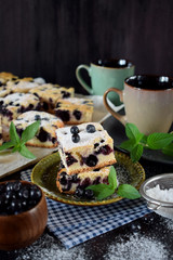 Finnish bilberry pie cut into square pieces sprinkled with sugar powder