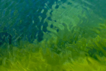 Fototapeta na wymiar Agua transparente de colores verde, azul y amarillo. Ideal para utilizar como imagen de fondo