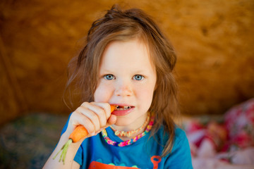 Little girl eats a carrot