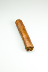 A brown cuban cigar freshly rolled on a table