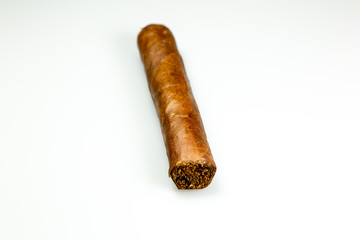 A brown cuban cigar freshly rolled on a table