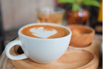 Coffee in a white cup and tea on the table.