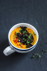 Caramelized balsamic onion pumpkin puree soup on dark background, top view. Copy space