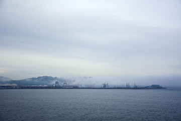 Photo of a port with fog, sea and sky