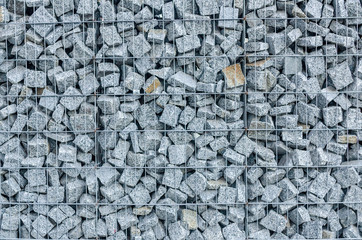 Stone fence texture made of rocks and fixed with wire for grunge background.