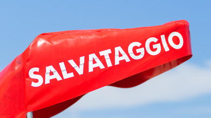 banner of Italian rescuer, baywatch, emergency (salvataggio) against blue sky