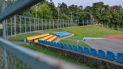 Rows of blue and yellow seats on stadium.