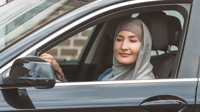 Muslim woman is driving a car