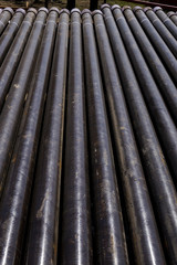 Oil Drill pipe. Rusty drill pipes were drilled in the well section. Downhole drilling rig. Laying the pipe on the deck. View of the shell of drill pipes laid in courtyard of the oil and gas warehouse.