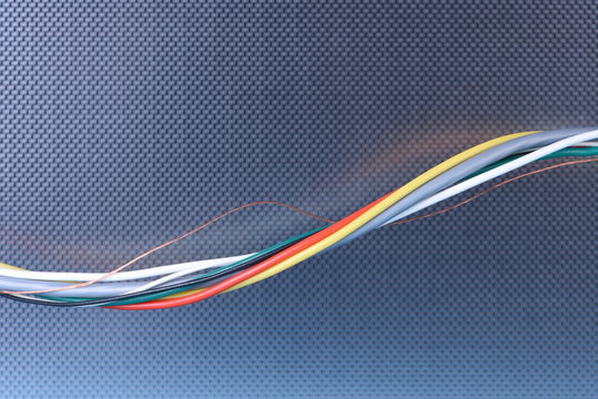 Colored electrical cable on metal abstract background
