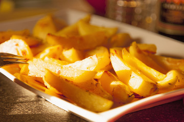 Close up shot of tasty french fries on white plate.