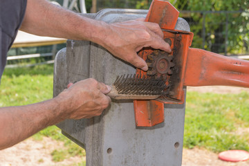 Man putzt Zahnrad mit Stahlbürste