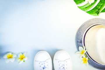 Summer flat lay scene with hat and green leaves on gray background with copy space, retro toned