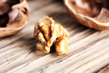 Walnut kernels and whole walnuts on rustic old table.