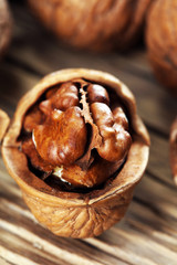 Walnut kernels and whole walnuts on rustic old table.