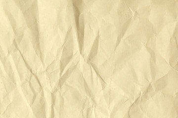 Paper beige color aged and wrinkled. Background of brown color with kinks and fraying.